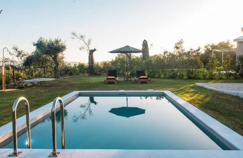 Ano Korakiana Villa | The villa's large private garden leads directly to the outdoor private pool.